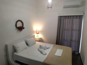 - une chambre avec un lit doté de draps et d'oreillers blancs dans l'établissement Nafpaktos beach Apartment, à Naupacte