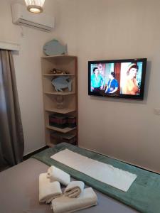 a bedroom with a tv on the wall with towels at Nafpaktos beach Apartment in Nafpaktos