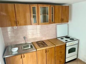 a kitchen with a sink and a stove and cabinets at Gray harmony rooms in Mostar