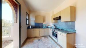 a kitchen with white cabinets and a large window at Palmeraie Village in Marrakesh