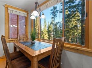 a dining room with a table and chairs and windows at Northstar Ski Trails Condo Walk to Village 3 Year-Round Hot Tubs in Rec. Center in Truckee