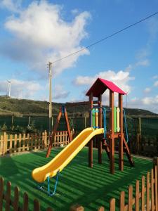 een speeltuin met een glijbaan in een tuin bij Casinhas dos Valados in Atouguia da Baleia