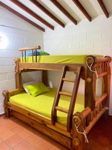2 beliches num quarto com lençóis verdes em Casa Vacacional Ciudadela Sol em San Jerónimo