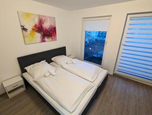 um quarto com uma cama com lençóis brancos e uma janela em City-Apartment & Lift ,Tannen C6 em Wuppertal