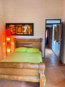 um quarto com uma cama de madeira e almofadas verdes em Casa Vacacional Ciudadela Sol em San Jerónimo
