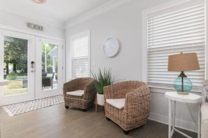 a living room with wicker chairs and a table at Southern Charming NEW Home Mins to Beach & Dwntn in Charleston +27 photos