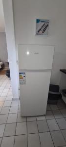 a white refrigerator sitting on a tiled floor at Paradies Caraïbes I in Les Abymes