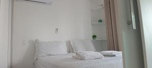 a white bed with white sheets and towels on it at Apartamento 2 quartos Meireles-Beach Class Fortaleza in Fortaleza