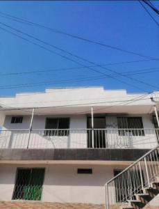 um edifício de apartamentos branco com uma varanda e escadas em ApartaSuite El Encanto em Barranquilla