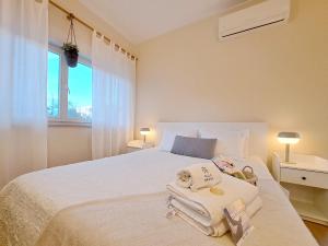 Un dormitorio con una cama blanca con toallas. en Villa Prana Guesthouse, Yoga & Ayurveda, en Portimão