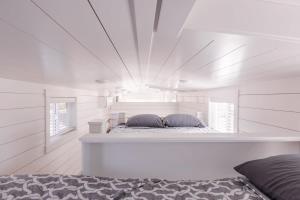 a bedroom with a bed in a white room at The Narrows Tiny Home in Apple Valley
