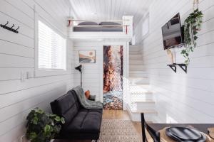 a living room with a couch and a door at The Narrows Tiny Home in Apple Valley