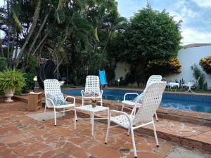 a group of chairs and a table next to a pool at RESIDENCIA-UNIV in Ciudad del Este