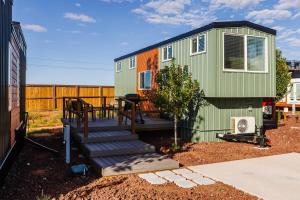 a green tiny house with stairs in a yard at The Narrows Tiny Home in Apple Valley