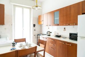 a kitchen with wooden cabinets and a table with chairs at La Spezia Holidays in La Spezia