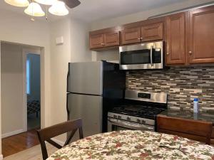 a kitchen with a stainless steel refrigerator and microwave at Charming Urban Apartment Getaway in Providence