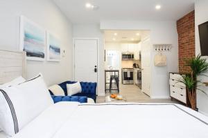 1 Schlafzimmer mit einem weißen Bett und einer Küche in der Unterkunft 240-15 Luxury Studio Prime Location W&D in New York