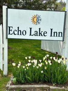 een bord voor een echo meer herberg met bloemen bij Echo Lake Inn in Tyson