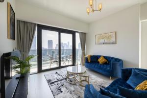 a living room with a blue couch and a large window at Luxury 2-BR Apt with Burj View in Dubai