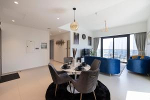 uma sala de jantar e sala de estar com mesa e cadeiras em Luxury 2-BR Apt with Burj View em Dubai