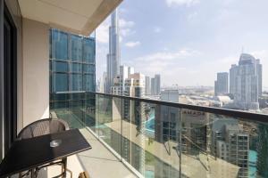 a balcony with a table and a view of the city at Luxury 2-BR Apt with Burj View in Dubai