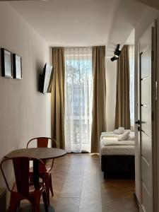 mały pokój z łóżkiem, stołem i oknem w obiekcie Apartamenty Planeta 212 Mielno centrum 100 m do morza w mieście Mielno