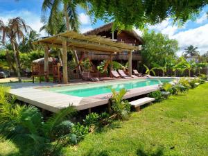a resort with a swimming pool and a house at Villa Caravelas Praia de Moitas in Amontada