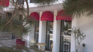 科尼亞的住宿－Pertevniyal Aziziye Hotel，一间设有红伞、桌子和树木的餐厅