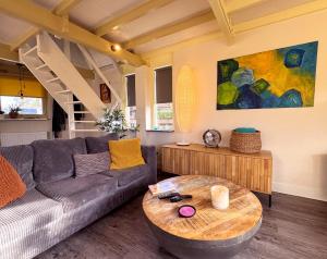 a living room with a couch and a table at Happy Little Maya Bee in Nieuwe-Niedorp