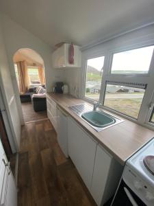 a small kitchen with a sink and a window at Chalet 5 Clarach Bay in Aberystwyth