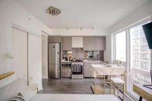 a kitchen with stainless steel appliances and a table at Brand New Studio in Heart of Downtown Toronto J8 in Toronto
