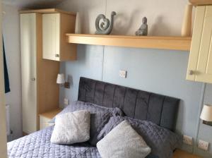 a bedroom with a bed with two pillows on it at 2 Bedroom 6 Birth Caravan - Towyn in Abergele