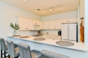 a kitchen with white cabinets and a white refrigerator at Cherry Grove Villa Close to Beach w Pool in Myrtle Beach