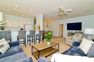 a living room with blue couches and a kitchen at Cherry Grove Villa Close to Beach w Pool in Myrtle Beach