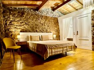 a bedroom with a bed and a stone wall at Quinta do Nobre in Marialva