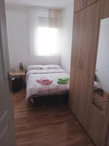 a small bedroom with a bed and a window at Apartman Gaga in Donji Komren