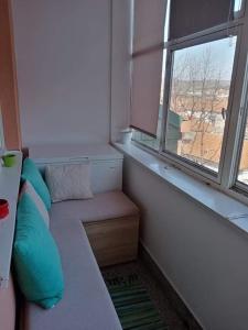 Habitación pequeña con sofá y ventana en Apartman Gaga, en Donji Komren