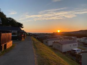 a sunset over a row of mobile homes at Chalet 5 Clarach Bay in Aberystwyth