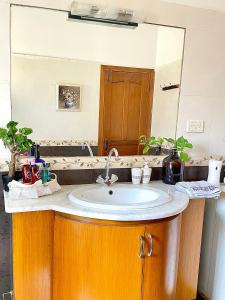 La salle de bains est pourvue d'un lavabo et d'un miroir. dans l'établissement Mohalla Rooftop Retreat, à Karachi