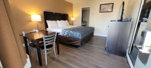 ein Hotelzimmer mit einem Bett, einem Tisch und einem Schreibtisch in der Unterkunft Econo Lodge Sacramento Convention Center in Sacramento