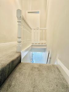 a hallway with stairs and a stair case at The Stunning house welcomes you in Liverpool