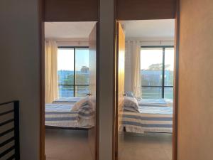 1 dormitorio con 2 camas y 2 ventanas en Casa Cielo, en Puerto Vallarta