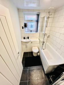 a bathroom with a toilet and a tub and a sink at The Stunning house welcomes you in Liverpool