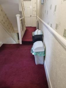 a hallway with a stairs with a trash can in it at Private Rooms in Croydon London in Thornton Heath