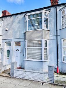 una casa azul con ventana y puerta blanca en The Stunning house welcomes you en Liverpool