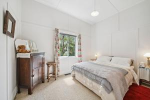 - une chambre blanche avec un lit et une fenêtre dans l'établissement The Cottage, à Blackheath