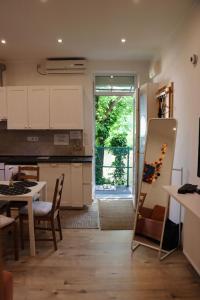 ブダペストにあるCozy Hillside Home in Budapest with Patioの白いキャビネット、テーブル、ドア付きのキッチン