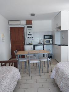 a kitchen with a table and chairs in a room at Mirador Azul Apart, 3 A,B,C in Las Grutas