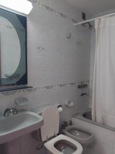 a bathroom with a toilet and a sink and a tub at Mirador Azul Apart, 3 A,B,C in Las Grutas