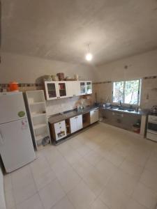 a large kitchen with a refrigerator and a sink at Casa en los Valles in Cafayate